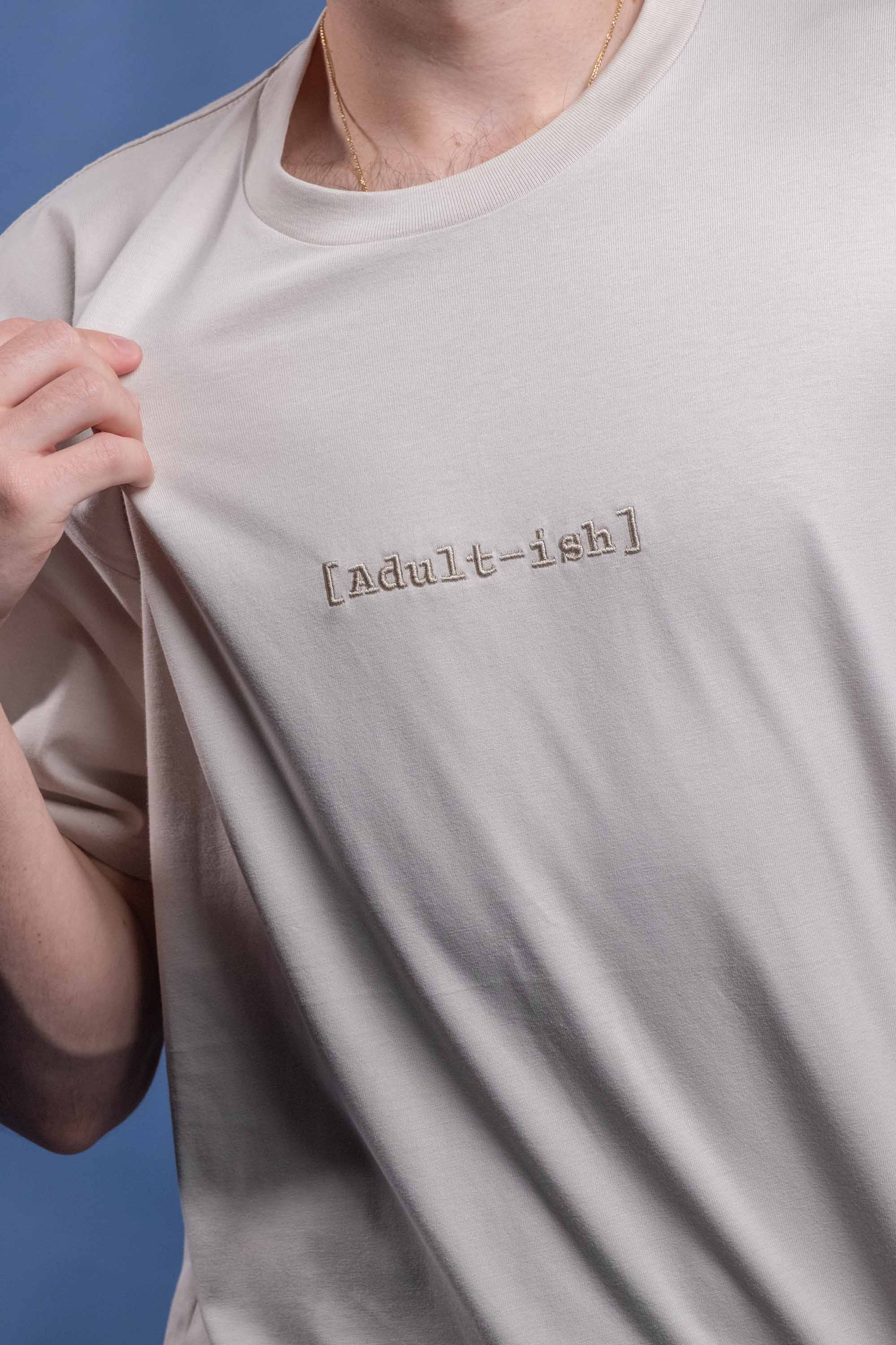 Preshrunk bone cotton t-shirt with neutral embroidered 'Adult-ish' design