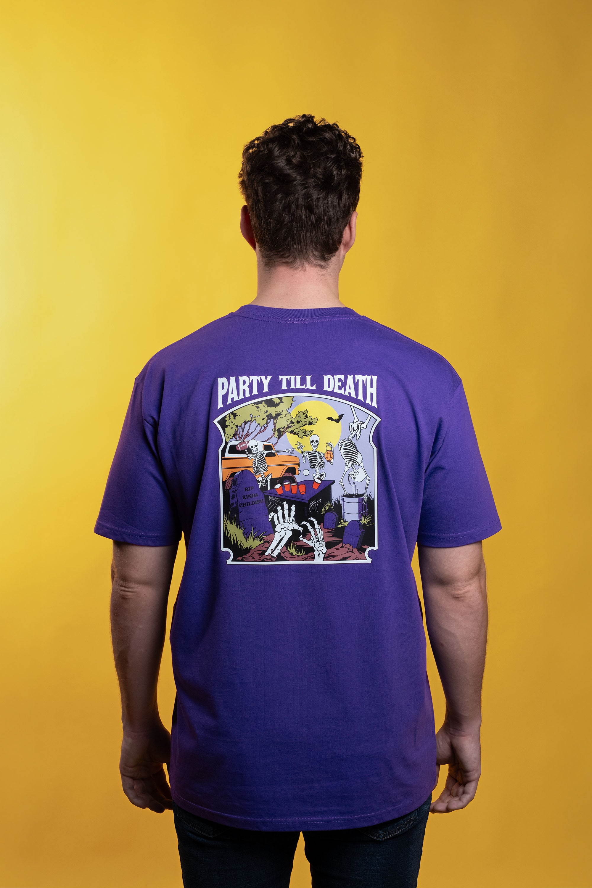 Purple preshrunk cotton t-shirt with glow-in-the-dark 'Afterlife' embroidery, printed graphic of tailgating skeletons