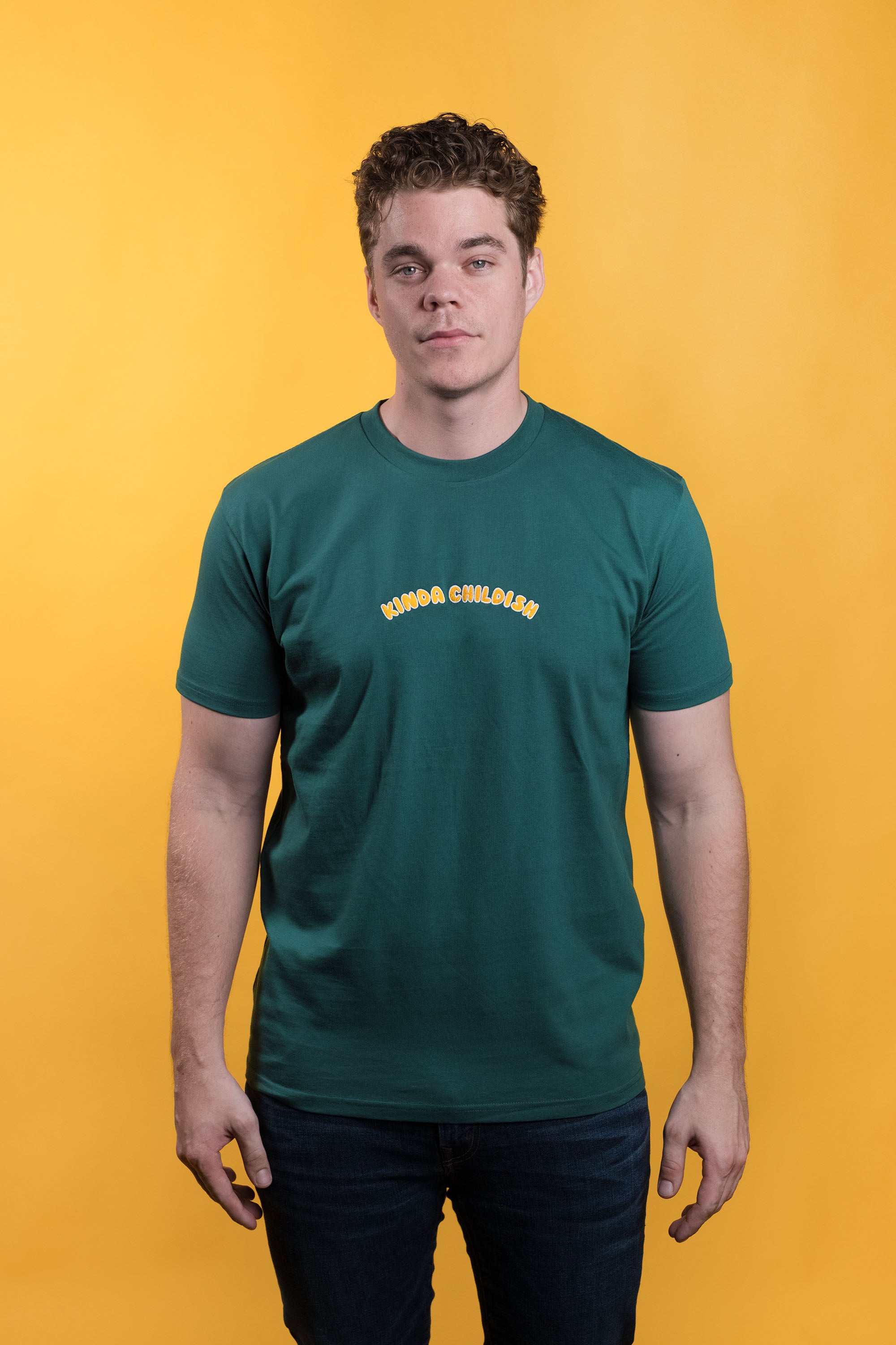 Preshrunk green cotton t-shirt with 'Kinda Childish' embroidered in an arch design