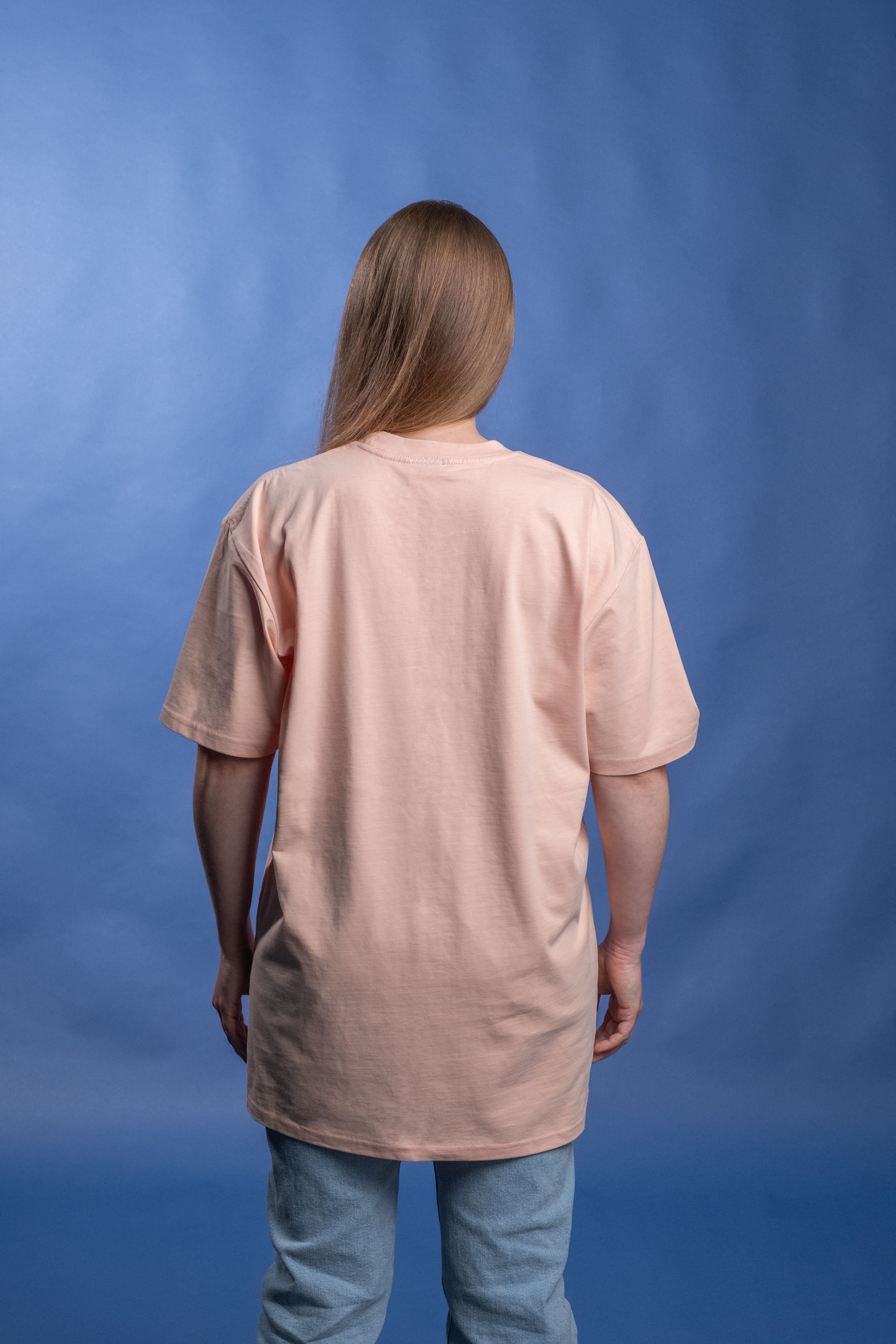 Preshrunk peach cotton t-shirt with 'Kinda Childish' embroidered in an arch design