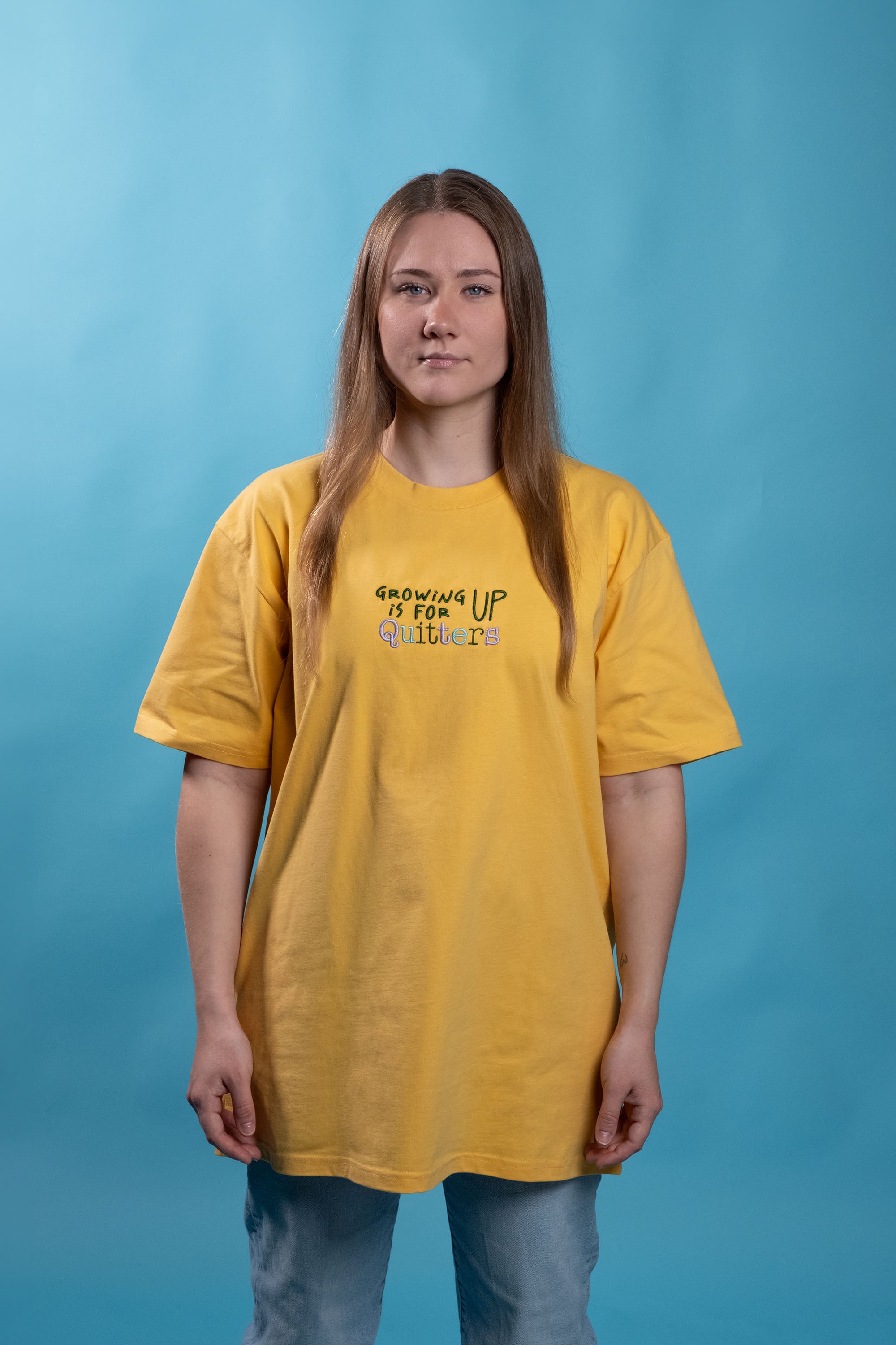 Preshrunk yellow cotton t-shirt with 'growing up is for quitters' embroidered design